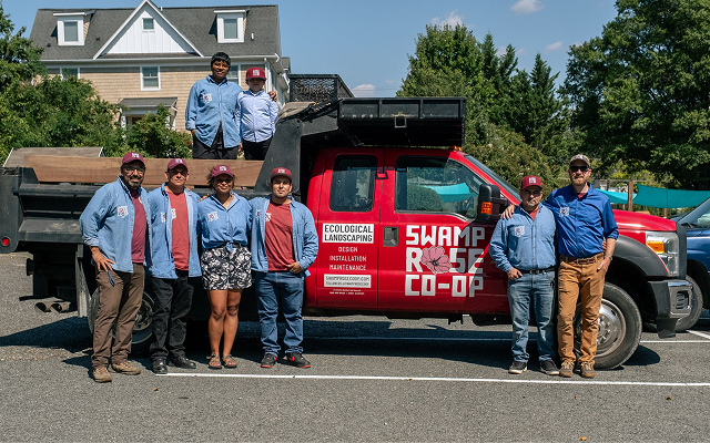 A photograh of worker owners of Swamp Rose Co-op. They stand around their pick up truck outside on a sunny day.